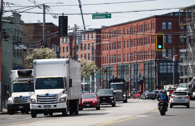 Traffic moves along Commercial Street in Portland at its intersection with Union Street on Monday. Mobility is still way down in Maine since the coronavirus pandemic struck, but Mainers have begun to move around more as statewide business restrictions have eased.
