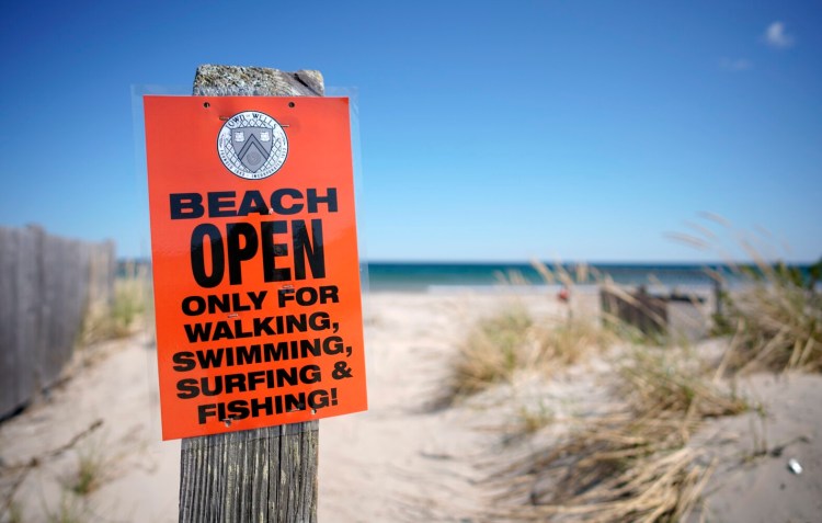 A sign at a public walkway entrance to Wells Beach on Tuesday informs visitors of the restrictions in using the beach. Wells reopened its beaches on Monday. 