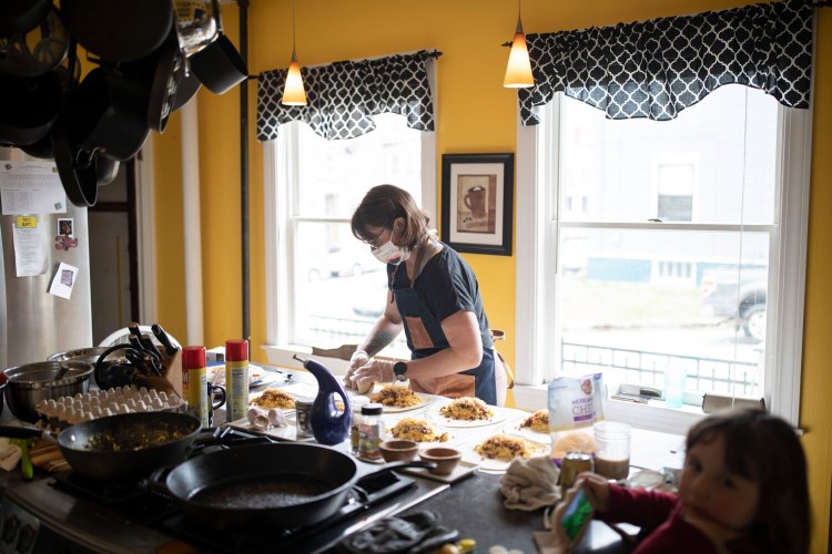 Erin Abraham makes breakfast burritos Friday in the kitchen of the Chadwick Inn in Portland, where she is the innkeeper. The burritos are sold and donated to Maine Medical Center employees. Abraham says, "We don’t know what the summer will look like. ... I don’t know if people will come here, and I don’t know if they should."