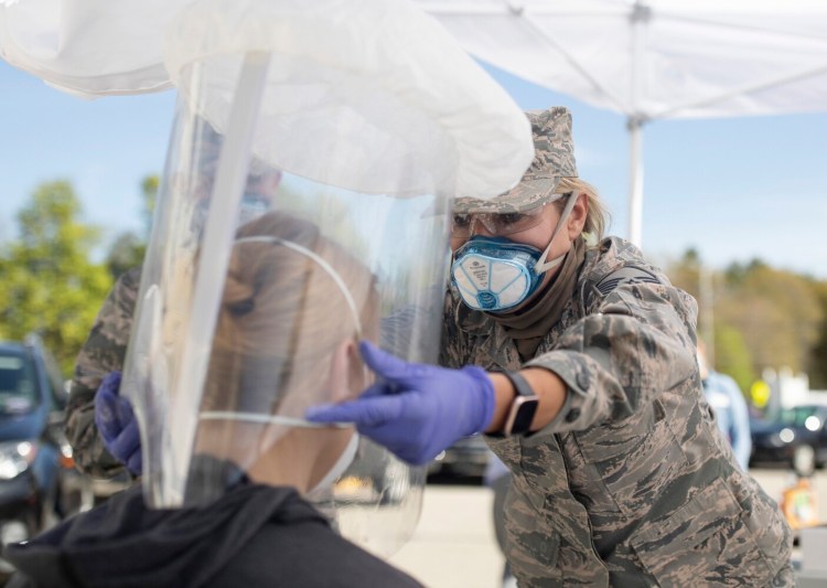 Air National Guard Master Sgt. Mary Pelletier helps a Gorham House staff member in a fit testing for personal protective equipment in the parking lot of the assisted living facility on May 19. National Guard members have been traveling around the state to congregate care facilities, fit testing and training workers for personal protective equipment.