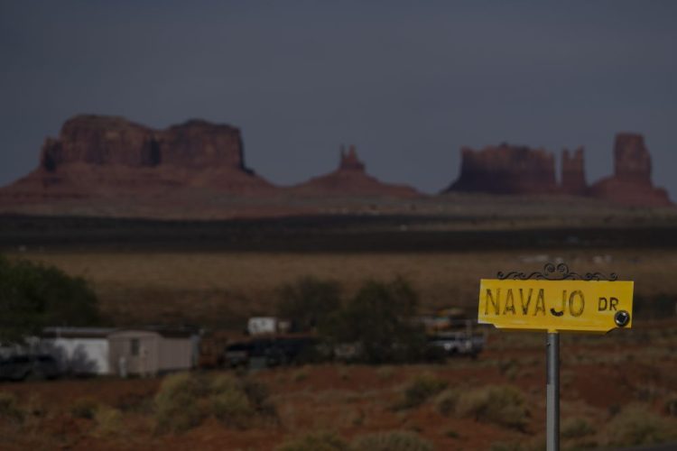 Sentinel Mesa, homes and other structures in Oljato-Monument Valley, Utah, on the Navajo Reservation, stand in the distance. Even before the pandemic, people living in rural communities and on reservations were among the toughest groups to count in the 2020 census. 

