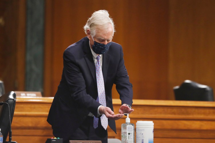 Sen. Angus King, I-Maine, uses hand sanitizer during a Senate Intelligence Committee nomination hearing for Rep. John Ratcliffe, R-Texas, on Capitol Hill in Washington on Tuesday. The panel is considering Ratcliffe's nomination for director of national intelligence. 