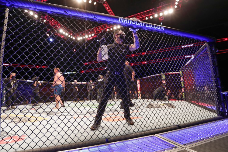 A worker wipes down the octagon between bouts during UFC 249 on Saturday in Jacksonville, Florida.