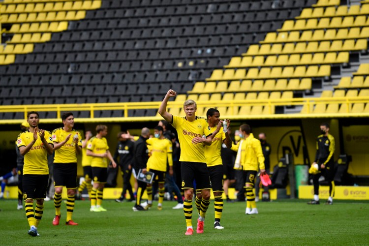Dortmund's Erling Haaland, center, and his teammates celebrate at the end of the German Bundesliga soccer match between Borussia Dortmund and Schalke 04 on Saturday in Dortmund, Germany. The German Bundesliga becomes the world's first major soccer league to resume after a two-month suspension because of the coronavirus pandemic. Dortmund won 4-0.