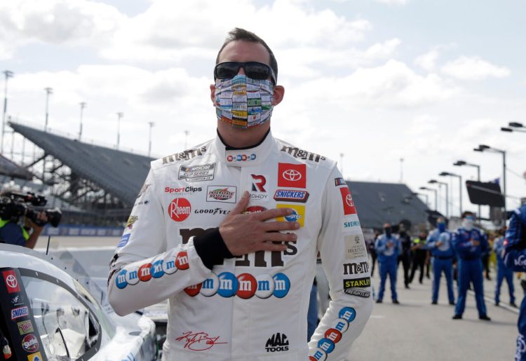 Kyle Busch, left, stands during the national anthem before the NASCAR Cup Series on Sunday in Darlington, S.C. Face coverings were required at the event, which went off without fans, and everyone involved did their part to follow the rules and stay safe. 