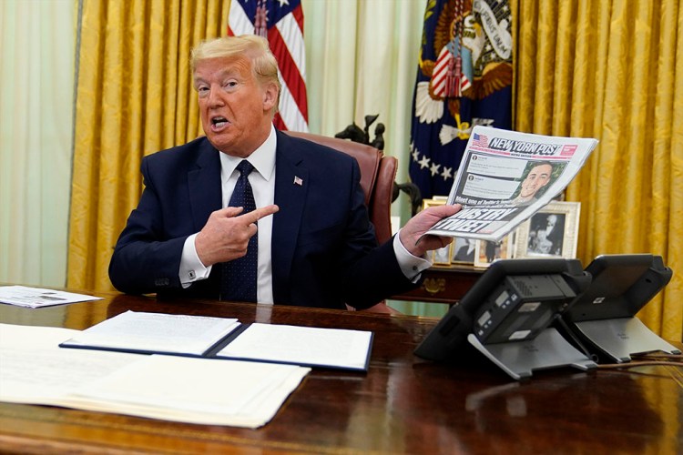 President Trump holds up a copy of the New York Post as speaks before signing an executive order Thursday aimed at curbing protections for social media giants.