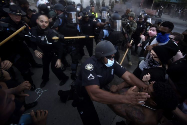 Police officers and protesters clash near CNN Center in Atlanta on Friday in response to George Floyd's death in police custody in Minneapolis on Memorial Day. The protest started peacefully earlier in the day.