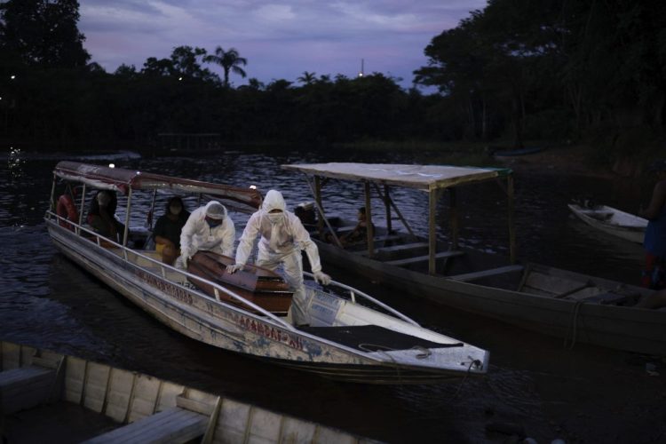 SOS Funeral workers transport the body of an 86-year-old woman who lived by the Negro River and is a suspected to have died of COVID-19, near Manaus, Brazil, on May 14. The virus has spread upriver from Manaus, creeping into remote riverside towns and indigenous territories to infect indigenous tribes. 