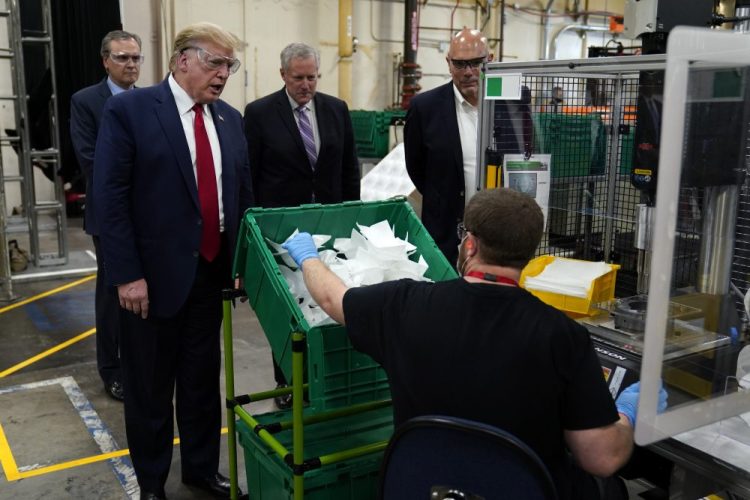 President Trump participates in a tour of a Honeywell International plant that manufactures personal protective equipment on Tuesday in Phoenix with Tony Stallings, vice president of Integrated Supply Chain at Honeywell, right and White House chief of staff Mark Meadows. 
