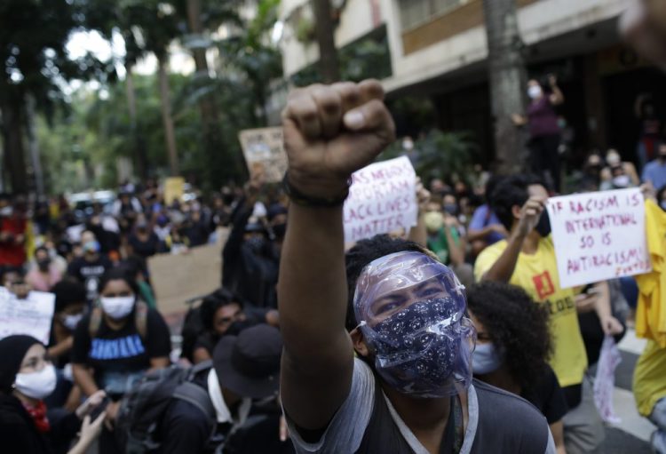 People protest against crimes committed by the police against black people in the favelas, outside the Rio de Janeiro's state government on  Sunday. The protest, called "Black lives matter," was interrupted when police used tear gas to disperse people. "I can't breathe", said some of the demonstrators, alluding to the George Floyd's death. 