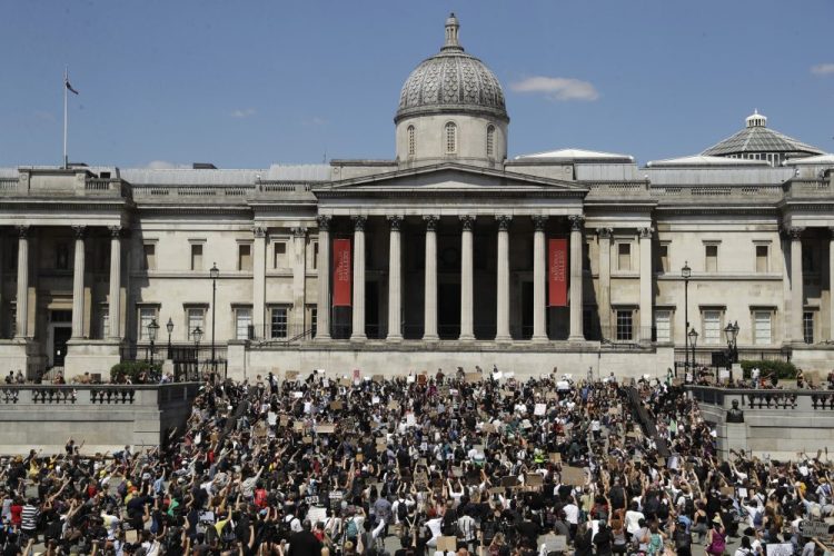 People, some of them kneeling gather in Trafalgar Square in London on Sunday to protest against the recent killing of George Floyd by police officers in Minneapolis. Many demonstrators were not wearing masks and most in the crowd were packed closely together. Britain has seen nearly 38,500 virus deaths, the second-highest in the world after the United States.