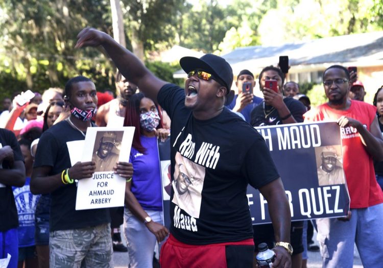 Keith Smith speaks to a crowd Tuesday as they march through a neighborhood in Brunswick, Ga., demanding answers regarding the death of Ahmaud Arbery.