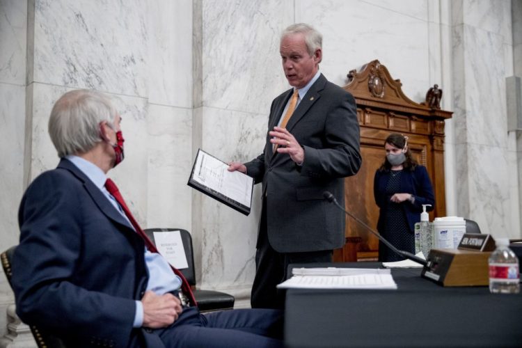 Chairman Sen. Ron Johnson, R-Wis., speaks with Sen. Rob Portman, R-Ohio, left, at the conclusion of a Senate Homeland Security and Governmental Affairs committee meeting on Capitol Hill in Washington on Wednesday after voting to issue a subpoena to Blue Star Strategies. 