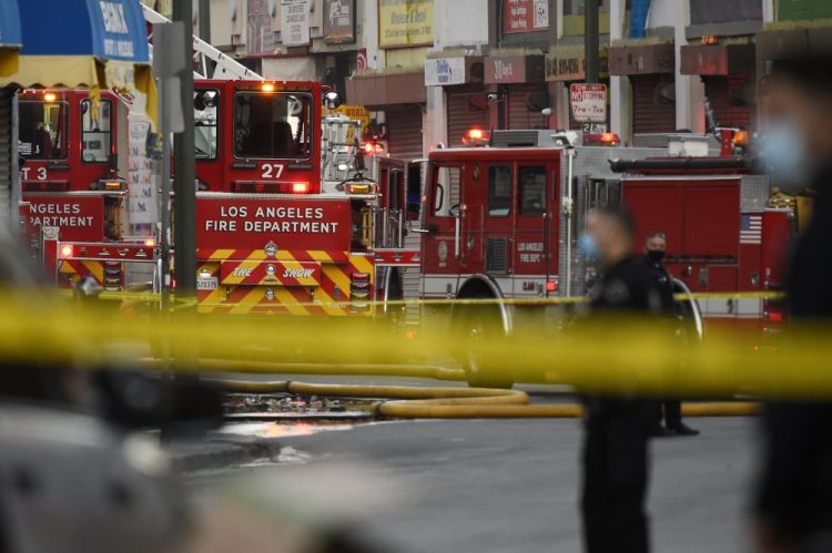 Los Angeles Police Department officers work the scene of a structure fire that injured multiple firefighters, according to a fire department spokesman, Saturday, in Los Angeles. 