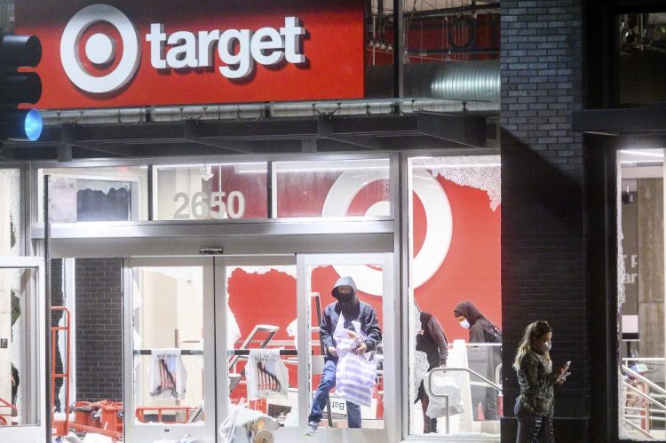People leave a vandalized Target store in Oakland, Calif., on Saturday, during protests against the death of George Floyd. 