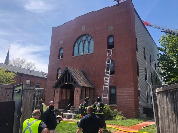 Firefighters work at the building that houses the Etz Chaim congregation and the  Maine Jewish Museum on Congress Street in Portland after a fire was reported there on Thursday.
