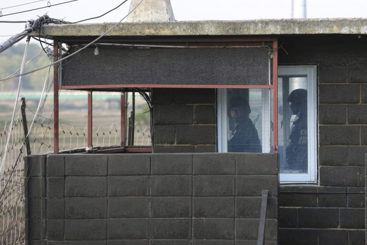 Army soldiers stand guard inside a military guard post in Paju, South Korea, near the border with North Korea. North and South Korean troops exchanged fire along their tense border on Sunday, the South's military said, blaming North Korean soldiers for targeting a guard post. 