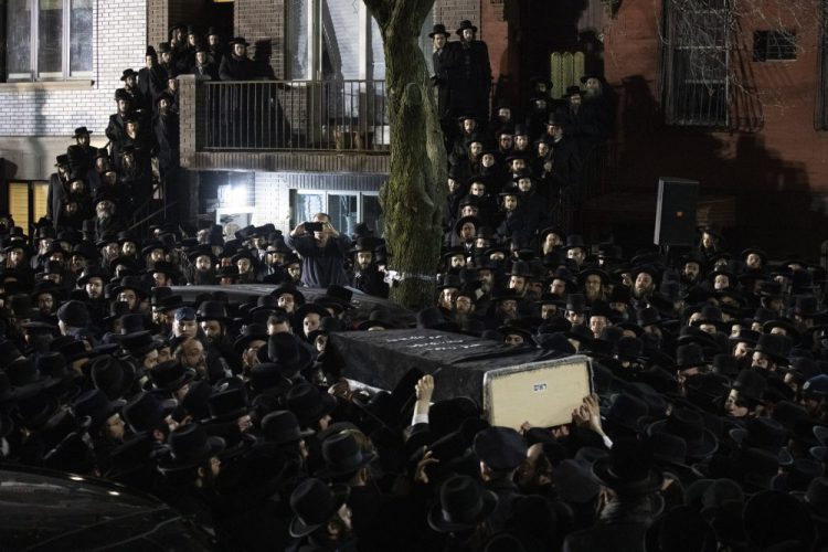 Orthodox Jewish men carry Moshe Deutsch's casket outside a Brooklyn synagogue Dec. 11 following his funeral in New York. Deutsch was killed in a shooting inside a Jersey City, N.J., kosher food market. Authorities said the attackers, David Anderson and Francine Graham, were motivated by a hatred of Jewish people and law enforcement.