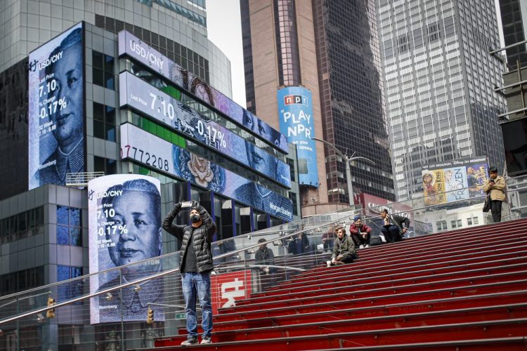 This March 20, 2020 file photo shows pedestrians in a sparsely populated Times Square in New York. COVID-19 has shaken theater fans and shuttered all New York City's venues, including Broadway, which grossed $1.8 billion last season and attracted a record 15 million people. 
