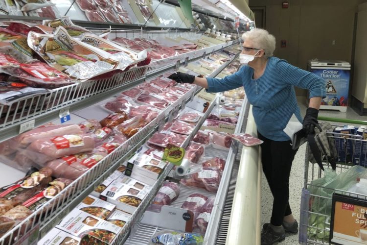 A shopper at a Publix Super Market in Atlanta looks at cuts of pork on May 5. This Publix store is limiting shoppers to two packages of chicken, like a number of other grocery retailers limiting meat purchases due to supply concerns amid the COVID-19 pandemic. 