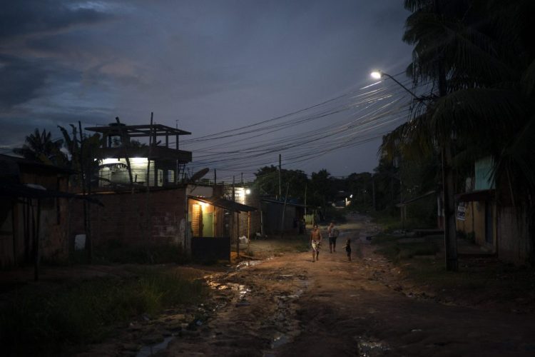 Residents walk on a dirt road in the Park of Indigenous Nations community, in Manaus, Brazil, on May 10. The South American country has Latin America's highest COVID-19 death toll. The country's hardest hit major city per capita is Manaus, where mass graves are filling up with bodies. 