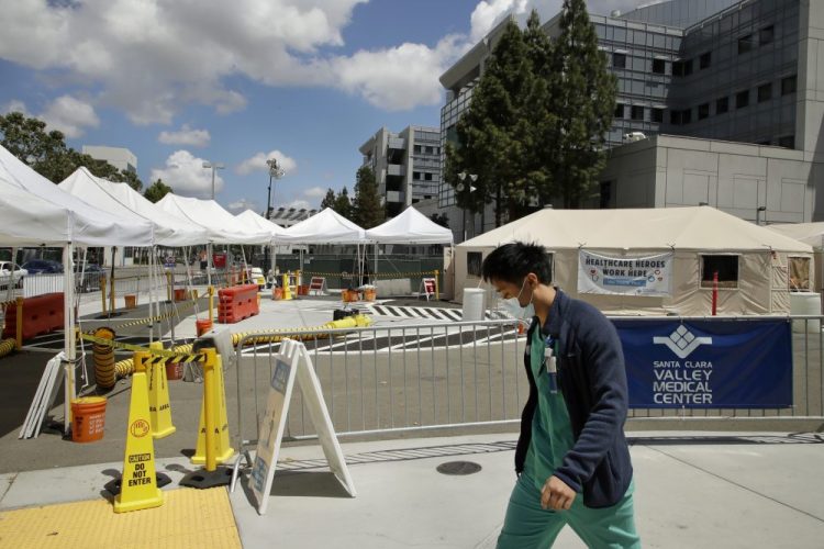 A health care worker walks past a COVID-19 test site Tuesday at Santa Clara Valley Medical Center in San Jose, Calif.