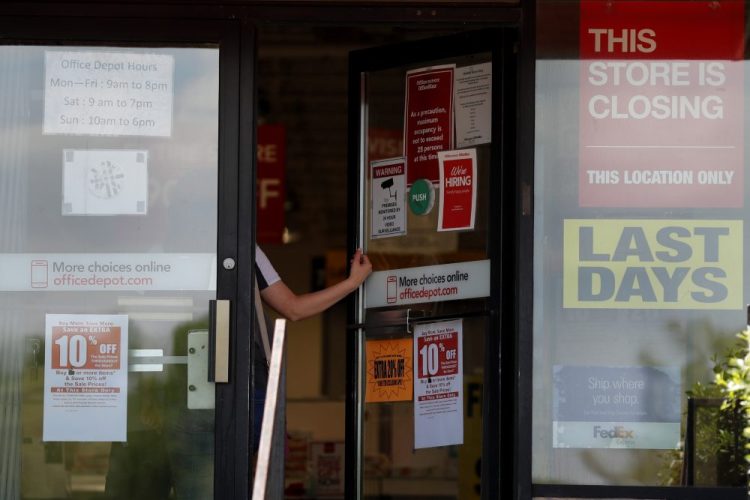 A person walks into an office supply retailer in Olivette, Mo., that is closing in the midst of the economic crash caused by the coronavirus pandemic.