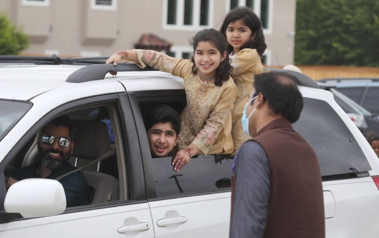 A family looks out from their vehicle during an Eid al-Fitr drive through celebration on Sunday outside a closed mosque in Plano, Texas. Many Muslims in America are navigating balancing religious and social rituals with concerns over the virus as they look for ways to capture the Eid spirit this weekend. 