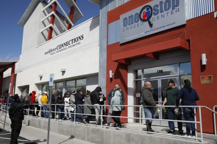 People wait in line for help with unemployment benefits March 17 at the One-Stop Career Center in Las Vegas. 
