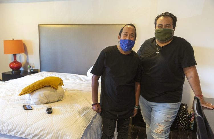Homeless couple, Matthew Padilla, left, and Juan "Nito" Padilla. Jr., in their room in a hotel in Los Angeles. For Matthew Padilla, a 34-year-old with a pacemaker and asthma, catching the novel coronavirus would likely mean death. So he jumped at the chance when his caseworker explained he could move into a hotel room for free as part of a new California program. 