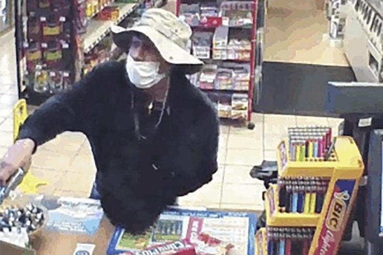 A man, believed to be William Rosario Lopez wearing a surgical mask, with a gun in a Connecticut convenience store March 26. Just how many criminals are taking advantage of the pandemic to commit crimes is impossible to estimate, but law enforcement officials have no doubt that the numbers are climbing.