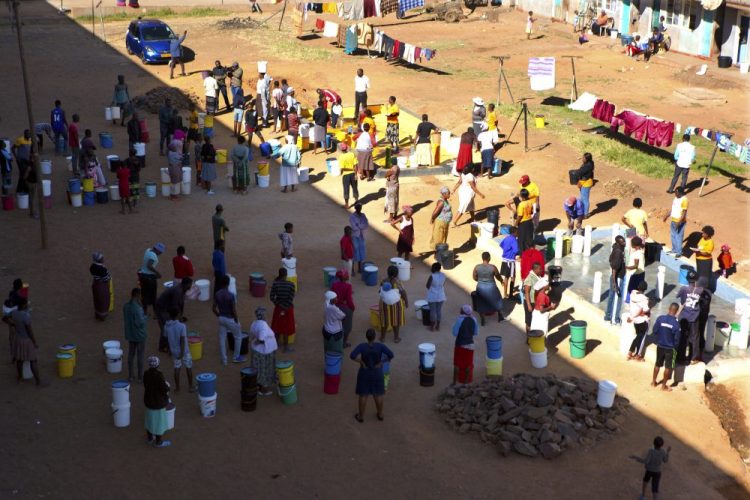 People wait to fetch water April 24 from a row of communal taps that Doctors Without Borders provided in a suburb of Harare, Zimbabwe. In Zimbabwe, clean water is often saved for doing dishes and flushing toilets. 

