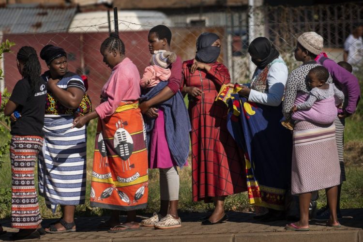 Women carrying their children line up for vegetables from the Jan Hofmeyer community services April 30 in Johannesburg, South Africa. The country is struggling to balance its fight against the coronavirus with its dire need to resume economic activity. The country with the Africa’s most developed economy also has its highest number of infections – more than 19,000.