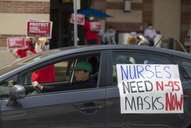 A car passes nurses protesting the lack of N95 respirators and other Personal Protective Equipment outside the UCLA Medical Center, Santa Monica, in April. (AP Photo/Damian Dovarganes)