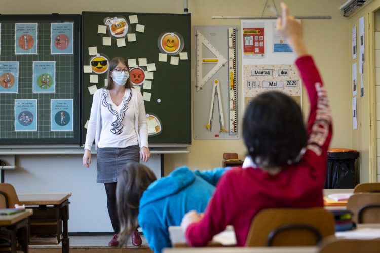 A teacher wears a face mask as she teaches Monday at a primary school in Morges, Switzerland. Swiss primary and secondary schools reopened with half of the students. 