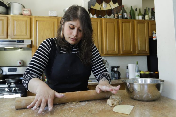 Gabby Namm, who has cooked professionally for about eight years,  prepares flatbread Tuesday in the Queens borough of New York. The coronavirus outbreak and the likely impact it's going to have on New York City's restaurants, how they serve, how they staff, how they pay, has disrupted all of that. 