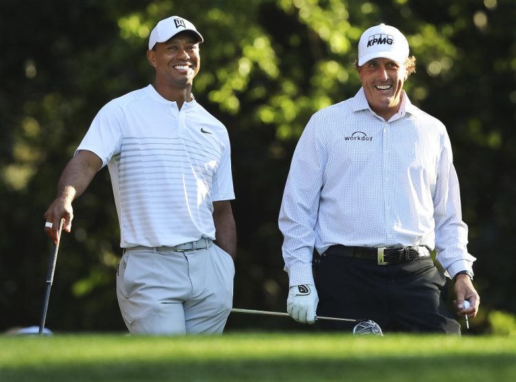 Tiger Woods, left, will in an event with Phil Mickelson, right, Tom Brady and Peyton Manning on Sunday. It will be Woods first time playing in a televised event in 98 days.