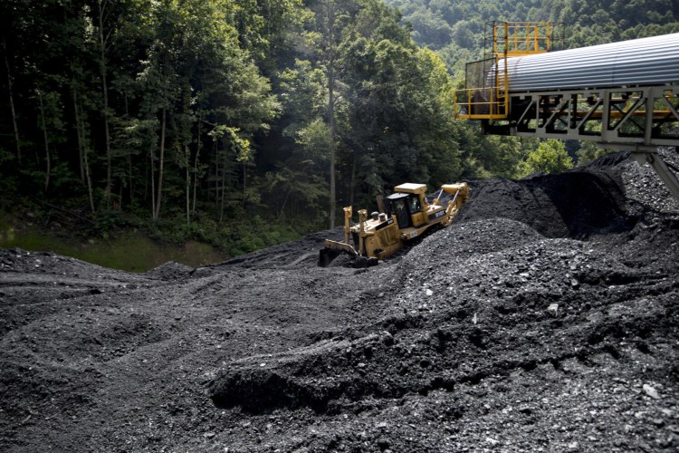 A bulldozer pushes raw coal in West Virginia. Approved PPP loans covered more than 78 percent of the industry's eligible payroll, compared to an average for all industries of 52 percent.