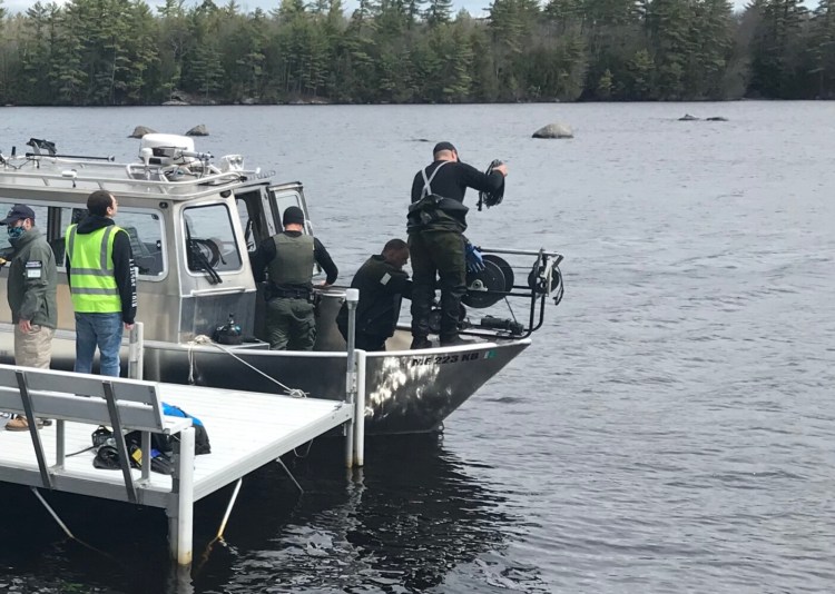 Game wardens attach a side scan sonar unit to the bow of the Maine Warden Service Dive boat. Divers on Wednesday recovered the body of man whose canoe capsized in Estes Lake in Sanford.
