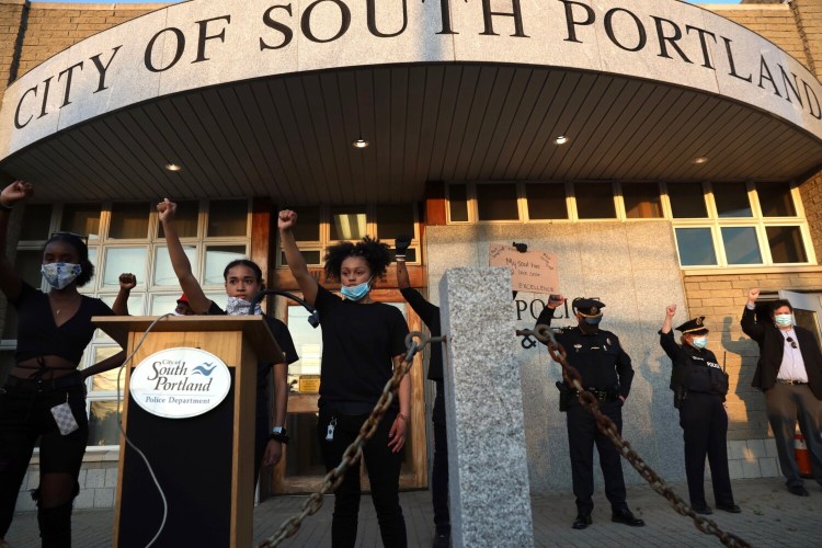 Student protesters are joined by police  at the South Portland police station in a demonstration against institutional racism in June 2020.