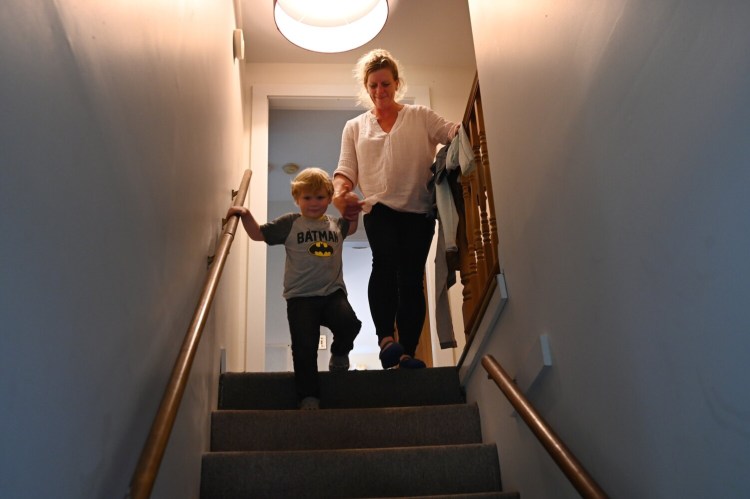 Rebecca Giles and her four-year-old son Andrew Benner make their way down the stairs of their apartment on June 11. Giles lost her housing and income because of the coronavirus pandemic and was living in a hotel recently until she was able to find an affordable apartment.