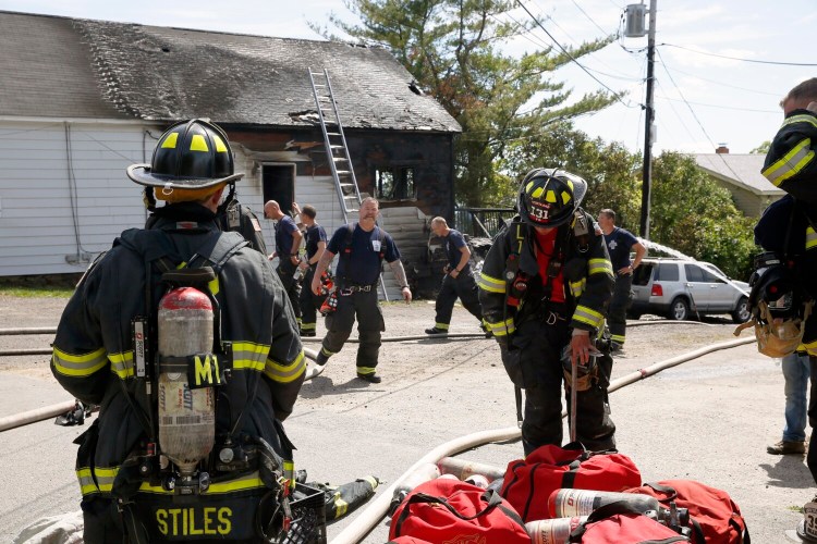 Firefighters work at the scene of the fire at the Peaks Island post office on Monday. 