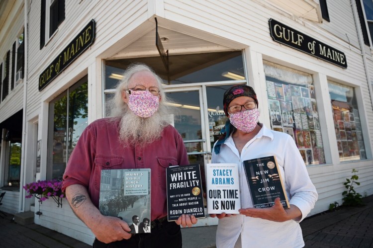  Gary Lawless and Beth Leonard, co-owners of Gulf of Maine Books in Brunswick hold books on race outside their book store. Books about race are in high demand at libraries and book stores in Maine, in response to the Black Lives Matter protests. 