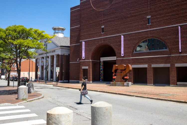 A pedestrian walks in front of the Portland Museum of Art in June.