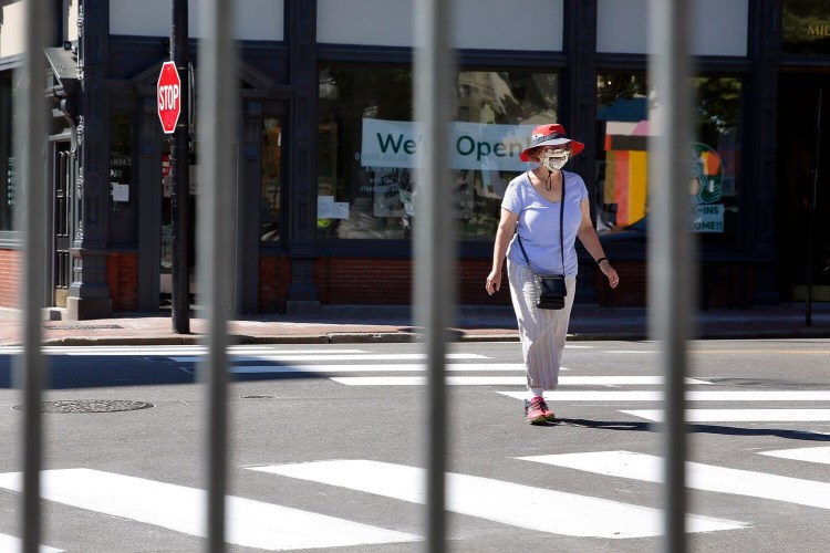 A woman crosses the intersection of Middle and Exchange streets in Portland on Wednesday. Several blocks of Exchange Street have been closed off for pedestrian traffic and outdoor dining.