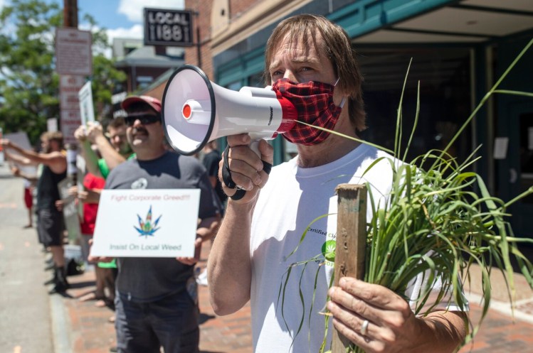 Dawson Julia, the director of the Maine Cannabis Coalition, leads a protest outside of Wellness Connection’s store in Portland on Friday. The group was protesting the company’s legal efforts to push the city of Portland and Maine to allow out-of-staters to have equal access to the recreational marijuana industry.