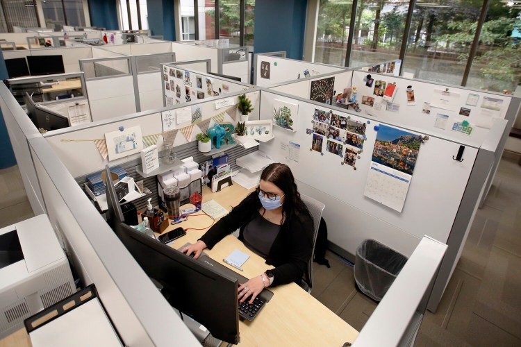 Rachel Eggleston, a claims associate at MEMIC in Portland, is one of two people who are working on her floor. MEMIC is among the businesses whose employees are slowly returning to the office, practicing social distancing, wearing masks and sanitizing surfaces.