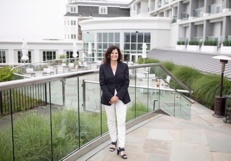 Nancy White, managing director of Cliff House Maine in York, poses on the back terrace of the hotel Tuesday. Cliff House Maine expects to fill about half of its 226 rooms over the Fourth of July weekend, said White. A year ago, nearly every room was booked.