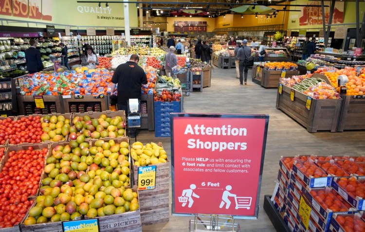 A sign at the entrance of a Hannaford supermarket, reminds customers to stay six feet apart while shopping in the store.