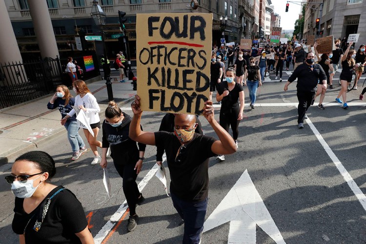 People march in Boston on Wednesday to protest police brutality, in response to the death of George Floyd, who died after being restrained by Minneapolis police officers on Memorial Day.